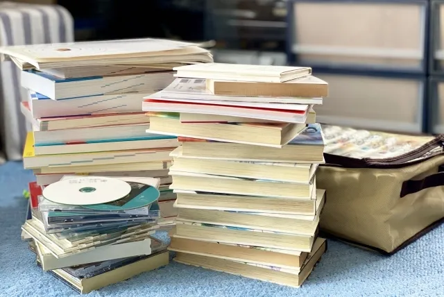 生前整理で床に山積みの本とCD