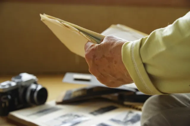 遺品整理で写真を見ている年配女性の手