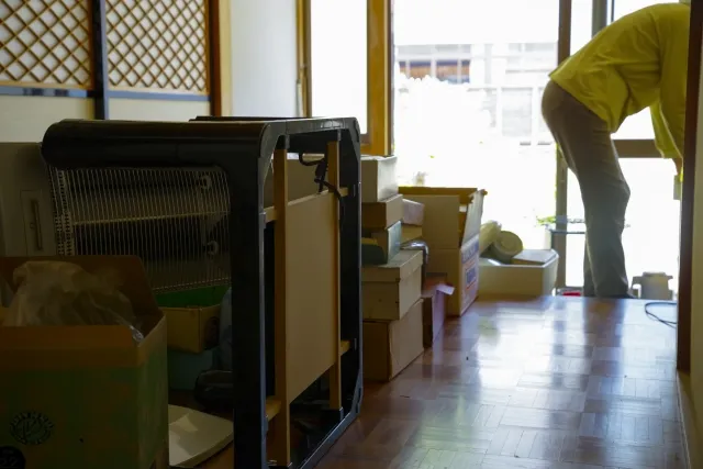 遺品整理で荷物の整理をしている年配女性