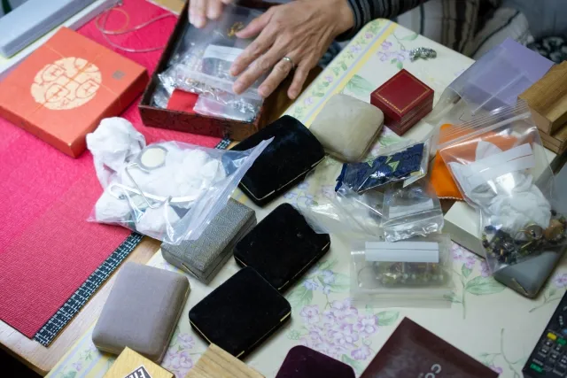 生前整理で貴金属を仕分けている年配女性の手