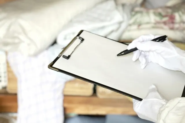 遺品整理で荷物を見てファイルに挟まった髪にメモをしようとしているところ