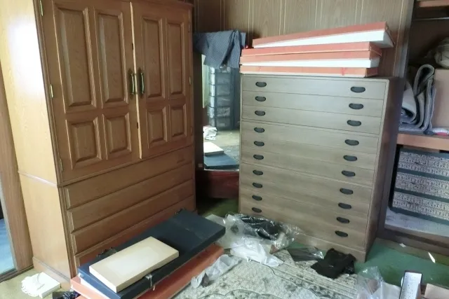 部屋に置かれた木製のタンスとワードローブなどの遺品