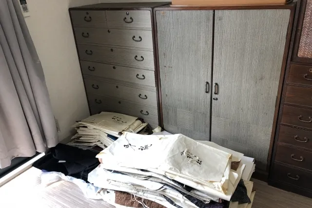 遺品の木製のタンスや着物の山