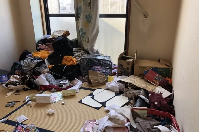 服や布、ゴミなど色々なものが散乱している畳の部屋