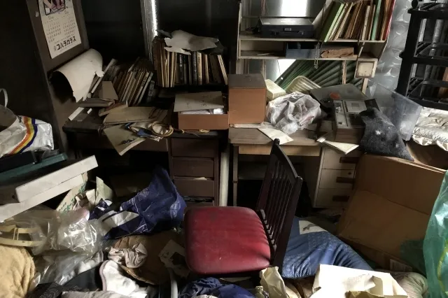 本や書類などの数多くの古い荷物が、乱雑に散らかっている部屋