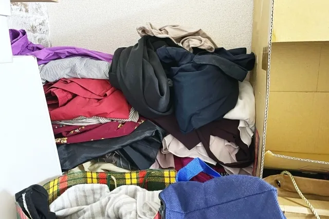 多数の洋服が積み上がって散乱している様子