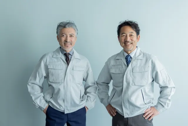 笑顔で並んでいる作業着を着た年配男性2人