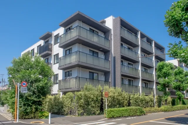 青空と5階建ての中層階のマンションの外観