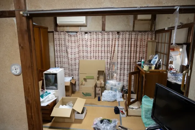 畳と砂壁の古い家の荷物をダンボールに入れて整理している途中