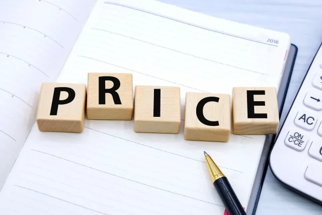 手帳の上にPRICEとアルファベット一文字ずつ書かれた木片が置かれている